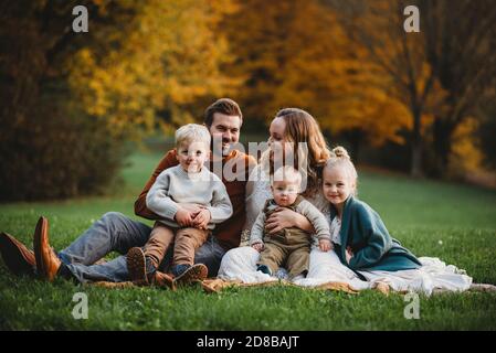 Bella famiglia in un parco sorridente in un giorno d'autunno Foto Stock