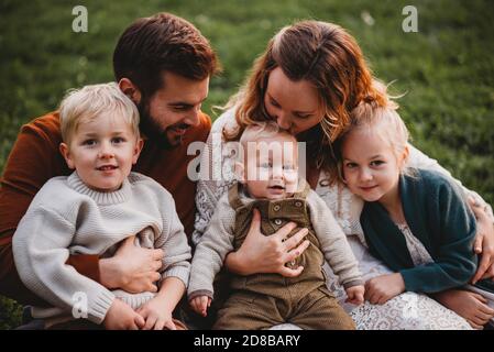 Bella famiglia seduta in un parco in una giornata di autunno Foto Stock