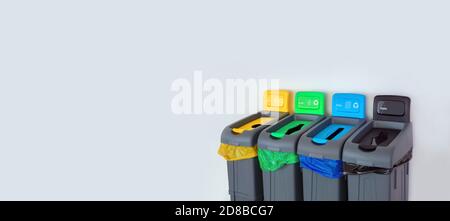 Contenitori di diversi colori per la raccolta di materiali riciclati. Cestino per rifiuti in plastica di colore verde, giallo, blu, nero. Smistamento separato di rifiuti Foto Stock