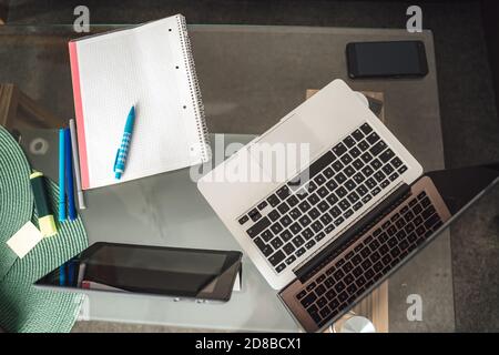 Direttamente sopra il computer portatile, il tablet digitale e il diario sul tavolino da caffè che rappresentano il concetto di lavoro da casa Foto Stock