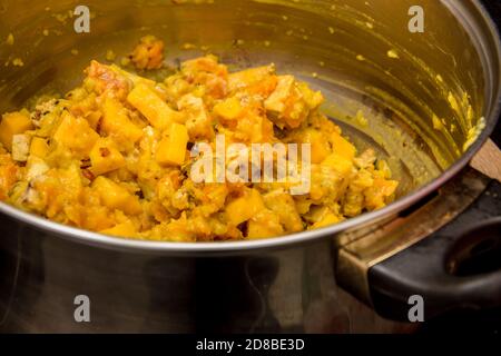 Primo piano del mix indiano di mango con giallo salsa di curry nella pentola di metallo Foto Stock