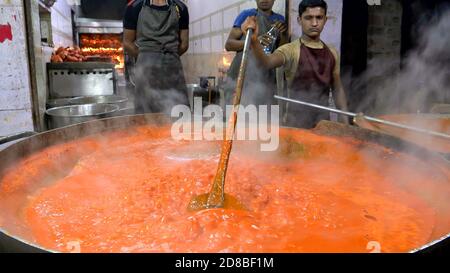 JAIPUR, INDIA - 20 MARZO 2019: Colpo di notte di un cuoco mescolando una grande pentola di salsa di curry ad un ristorante a jaipur, india Foto Stock