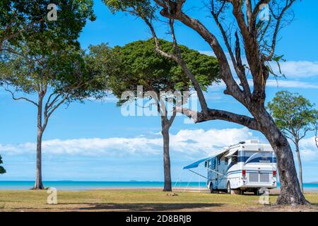 Grande motorhome parcheggiata sotto gli alberi sulla spiaggia, Clairview, Queensland centrale, Australia Foto Stock