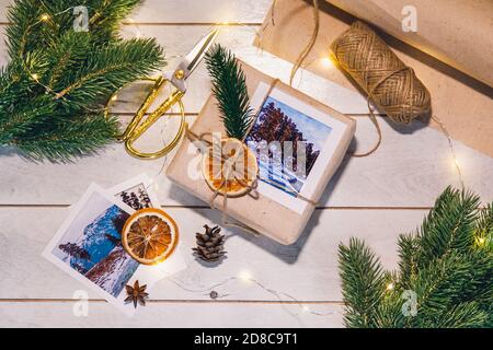 Confezione regalo senza sprechi e stile ecologico: Carta ruvida naturale, corda di iuta, rametti di abete rosso, forbici vintage. Foto Stock