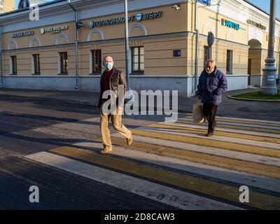 Mosca. Russia. 28 ottobre 2020 UN uomo che indossa una maschera attraversa la strada in un passaggio pedonale. Giornata di sole in città. Il concetto di personale Foto Stock