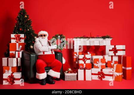 Bella bella bella grasso sovrappeso allegra Santa seduta in poltrona decorata soggiorno che tiene in mani festal corona christmastime isolato luminoso Foto Stock