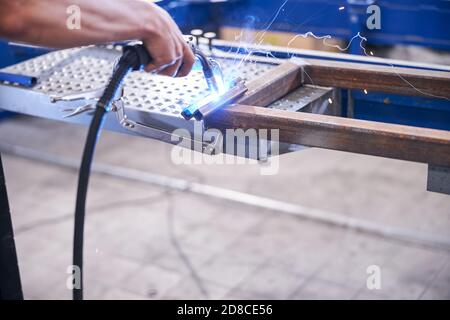 Lavoro maschile saldando utensili in metallo in garage Foto Stock