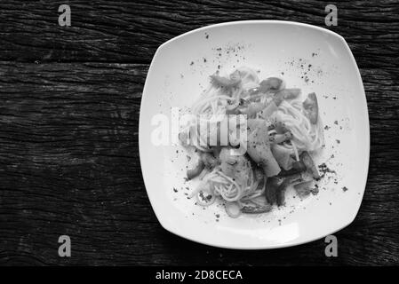 Spaghetti al salmone con pomodoro fresco contro tavola di legno Foto Stock