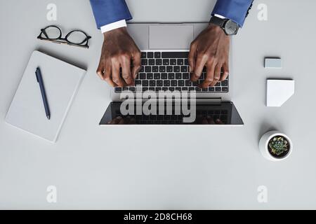 Vista ad alto angolo di uomo d'affari che scrive sul computer portatile He comunicare online sul suo posto di lavoro Foto Stock