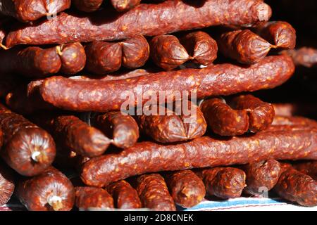 Primo piano di salsicce essiccate al pepe rosso sul mercato agricolo per la vendita Foto Stock