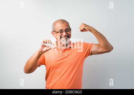 Indiano asian anziano o anziano che controlla la temperatura usando il termometro e saturazione di ossigeno con ossimetro Foto Stock