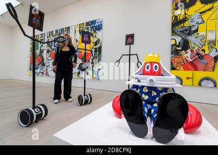 Londra, Regno Unito. 29 ottobre 2020. Un membro del personale si pone accanto alla visione di robot e di un'opera d'arte in omaggio a Marcel Duchamp. Anteprima di Philip Colbert: Lobsteropolis, una nuova mostra alla Galleria Saatchi di Piazza Sloane. La nuova mostra ispirata al blocco è disponibile per la visualizzazione remota tramite robot. La mostra (29 ottobre – 29 novembre) è il più grande sondaggio del Regno Unito sull'universo di Colbert fino ad oggi e comprende dipinti e sculture inediti su larga scala. Credit: Stephen Chung / Alamy Live News Foto Stock