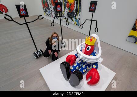 Londra, Regno Unito. 29 ottobre 2020. Un membro del personale si pone accanto alla visione di robot e di un'opera d'arte in omaggio a Marcel Duchamp. Anteprima di Philip Colbert: Lobsteropolis, una nuova mostra alla Galleria Saatchi di Piazza Sloane. La nuova mostra ispirata al blocco è disponibile per la visualizzazione remota tramite robot. La mostra (29 ottobre – 29 novembre) è il più grande sondaggio del Regno Unito sull'universo di Colbert fino ad oggi e comprende dipinti e sculture inediti su larga scala. Credit: Stephen Chung / Alamy Live News Foto Stock