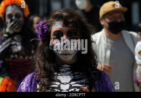 Città del Messico, Messico. 27 Ott 2020. CITTÀ DEL MESSICO, MESSICO - OTTOBRE 27: Una persona con il loro volto make-up come cranio per celebrare le tradizioni messicane del giorno dei morti (dia de Muertos) visto in centro in mezzo alla nuova pandemia di coronavirus il 27 ottobre 2020 a Città del Messico, Messico. Credit: Ricardo Castelan Cruz/Eyepix Group/The Photo Access Credit: The Photo Access/Alamy Live News Foto Stock