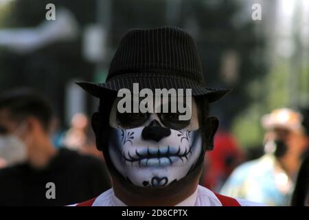 Città del Messico, Messico. 27 Ott 2020. CITTÀ DEL MESSICO, MESSICO - OTTOBRE 27: Una persona con il loro volto make-up come cranio per celebrare le tradizioni messicane del giorno dei morti (dia de Muertos) visto in centro in mezzo alla nuova pandemia di coronavirus il 27 ottobre 2020 a Città del Messico, Messico. Credit: Ricardo Castelan Cruz/Eyepix Group/The Photo Access Credit: The Photo Access/Alamy Live News Foto Stock