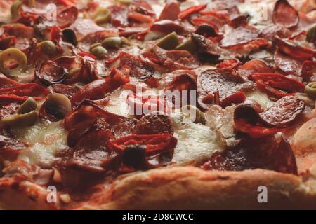 Pizza. Pizza Diablo (salsicce, salame, pancetta, formaggio, funghi, olive, peperoni, peperoni, peperoni, salsa di pomodoro italiana) primo piano. Foto Stock