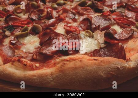 Pizza. Pizza Diablo (salsicce, salame, pancetta, formaggio, funghi, olive, peperoni, peperoni, peperoni, salsa di pomodoro italiana) primo piano. Foto Stock