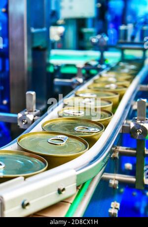 Prodotti alimentari in scatola su nastro trasportatore in magazzino di distribuzione. Concetto di sistema di trasporto pacchi Foto Stock