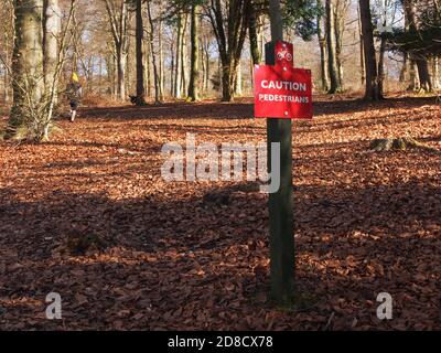 I pedoni segnalano la presenza di un cartello nel bosco, segnalando ai ciclisti che i pedoni utilizzano i sentieri Foto Stock