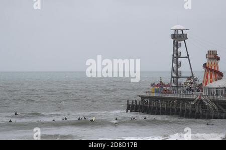 I surfisti si godono le grandi onde nel mare al largo della spiaggia di Bournemouth in Dorset. Il Met Office ha avvertito che i downpour torrenziali sono previsti per portare 'infuori' in tutto il Regno Unito con grandi onde, pioggia pesante, forti galee e potenziali inondazioni fluviali che colpiscono la costa occidentale dell'Inghilterra, gran parte del Galles e parti della Scozia da giovedì. Foto Stock