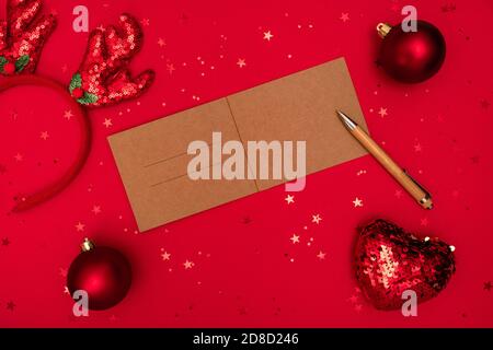 Lettera di Natale per congratulazioni con penna e decorazioni su superficie rossa. Buon Natale felice anno nuovo concetto Foto Stock