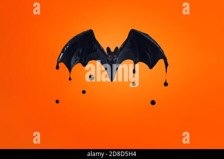 bat nero con occhi rossi su sfondo arancione. Foto Stock