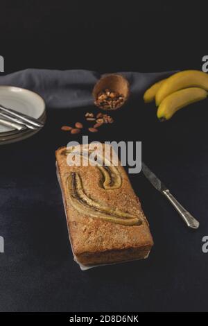 Pane di noce di banana isolato su sfondo scuro. Ingredienti di pane alla banana. Deliziosi pasticcini fatti in casa. Vista frontale. Foto Stock