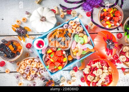 Set di dolci e caramelle di Halloween. Vari dolcetti per i bambini per Halloween - caramelle, colazione a base di cereali, dolci, con pranzo a scuola e secchio, piatto cop Foto Stock