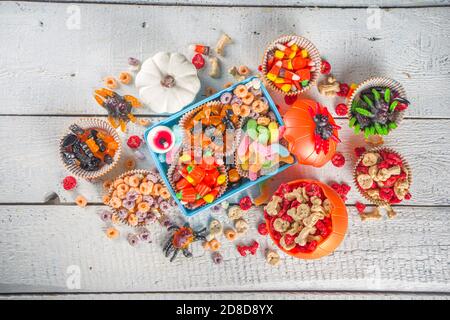 Set di dolci e caramelle di Halloween. Vari dolcetti per i bambini per Halloween - caramelle, colazione a base di cereali, dolci, con pranzo a scuola e secchio, piatto cop Foto Stock