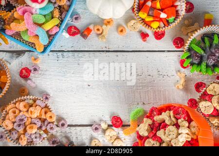 Set di dolci e caramelle di Halloween. Vari dolcetti per i bambini per Halloween - caramelle, colazione a base di cereali, dolci, con pranzo a scuola e secchio, piatto cop Foto Stock