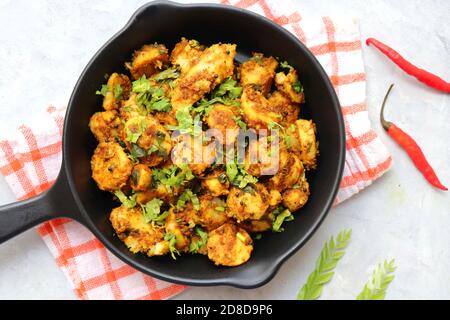 Mescolare le radici di taro fritte. Arbi ki sabji, Taro radici masala curry. Arbi Masala. Guarnito con coriandolo, peperoncino rosso e foglie di curry. Copia spazio. Foto Stock