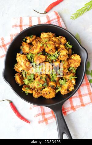 Mescolare le radici di taro fritte. Arbi ki sabji, Taro radici masala curry. Arbi Masala. Guarnito con coriandolo, peperoncino rosso e foglie di curry. Copia spazio. Foto Stock