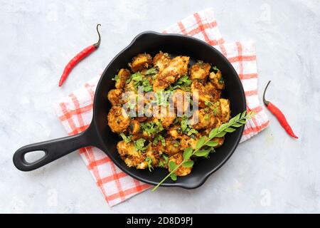 Mescolare le radici di taro fritte. Arbi ki sabji, Taro radici masala curry. Arbi Masala. Guarnito con coriandolo, peperoncino rosso e foglie di curry. Copia spazio. Foto Stock