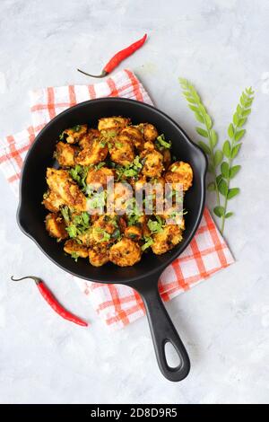 Mescolare le radici di taro fritte. Arbi ki sabji, Taro radici masala curry. Arbi Masala. Guarnito con coriandolo, peperoncino rosso e foglie di curry. Copia spazio. Foto Stock