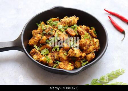 Mescolare le radici di taro fritte. Arbi ki sabji, Taro radici masala curry. Arbi Masala. Guarnito con coriandolo, peperoncino rosso e foglie di curry. Copia spazio. Foto Stock