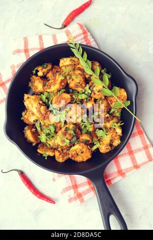 Mescolare le radici di taro fritte. Arbi ki sabji, Taro radici masala curry. Arbi Masala. Guarnito con coriandolo, peperoncino rosso e foglie di curry. Copia spazio. Foto Stock