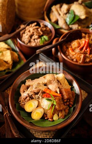 Nasi Gudeg. Pasto giavanese di riso con stufato di jackfruit, curry di pollo e stufato piccante di cracker di pelle di bestiame bovino Foto Stock