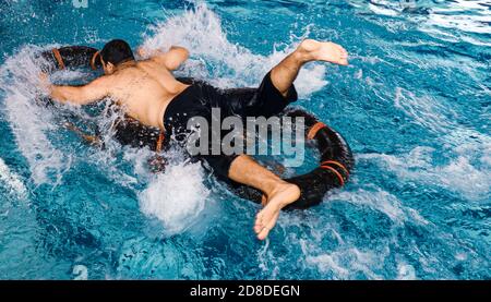 Giovane uomo nuotare il crawl anteriore in una piscina - underwater shot Foto Stock