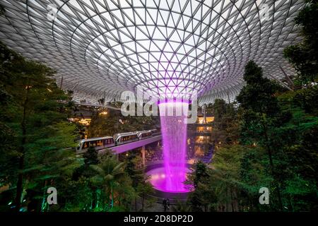 SINGAPORE - 3 MARZO 2020: Cascata al GIOIELLO del centro commerciale al terminal 4 dell'aeroporto changi di singapore in serata. Spettacolo di luci sull'acqua Foto Stock