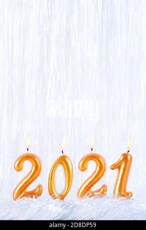 Quattro candele dorate scrivono i numeri fiamma. Felice anno nuovo 2021 Foto Stock