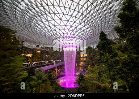 SINGAPORE - 3 MARZO 2020: Cascata al GIOIELLO del centro commerciale al terminal 4 dell'aeroporto changi di singapore in serata. Spettacolo di luci sull'acqua Foto Stock