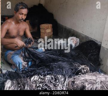 Le 50-60 famiglie di un piccolo villaggio musulmano dominato, Pabitat, nel distretto di Howrah, a 40 km dalla città di Howrah sotto la stazione di polizia di Domjur, Stanno lavorando per fare i capelli per la Dea Durga in tempo per il festival di avvicinamento per un lungo time.They preparare i capelli da balle di iuta e dipingere i trefoli in nero color.The capelli saranno forniti a mozzi modellatore di argilla nella città e diverse parti dello stato compreso Kumartuli.Anisur rahaman, uno degli abitanti del villaggio ha detto, il villaggio è già frequentato da agenti provenienti da mozzi modellatori di argilla per la fornitura di capelli, che è principalmente utilizzato per 'abeki protima' Foto Stock