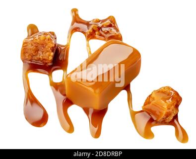 Composizione di caramelle morbide isolate su sfondo bianco, vista dall'alto. Pezzi di caramello dolce con salsa o sciroppo d'acero Foto Stock