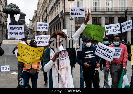 Madrid, Spagna. 29 Ott 2020. Una donna grida slogan mentre i manifestanti tengono cartelli durante una protesta in cui la comunità nigeriana a Madrid dimostra di chiedere la fine della SARS (Special Anti-Robbery Squad), la fine della brutalità della polizia e la fine della corruzione in Nigeria. Credit: Marcos del Mazo/Alamy Live News Foto Stock