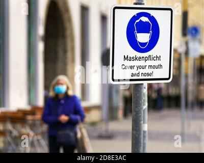 Monaco di Baviera, 26 ottobre 2020: Un segno con un pittogramma di maschera e l'iscrizione 'Mask requirement' si trova su Max-Joseph-Platz di Monaco, Baviera, Germania --- München, 26.10.2020: Ein Swild mit Masken-Piktogramm und der Aufschrift 'Maskenpflicht' steht am Münchener Max-Joseph-Platz, München, Bayern, Deutschland Foto Stock