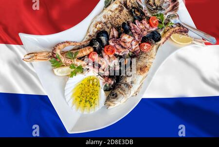 Incredibile piatto di pesce con pesce, capesante, gamberi, polpi serviti sulla bandiera croata Foto Stock