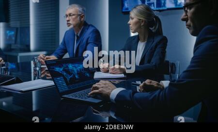 Funzionari dell'agenzia governativa che hanno discussione sulla riunione di emergenza. Persone serie che negoziano nella sala conferenze. Nelle schermate background (sfondo) Foto Stock