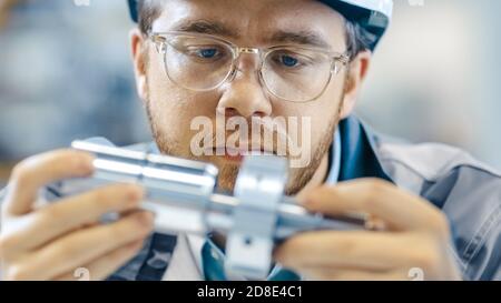 Primo piano delle classi di usura degli ingegneri industriali e Hard Hat collega due componenti progettati. Precisione nella progettazione meccanica. Foto Stock