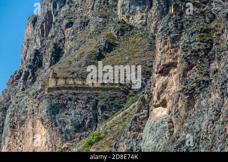 Immagine in pietra del dio Inca Viracocha e granai Inca in rovina, Ollantaytambo, Perù Foto Stock