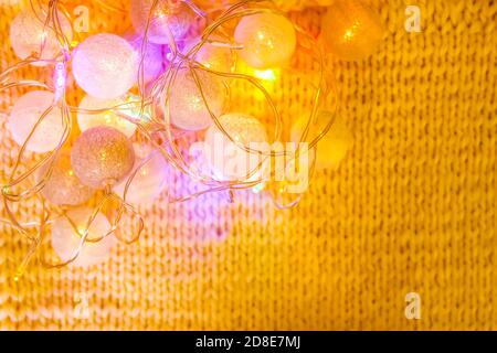 Luci natalizie con lanterne rotonde su fondo in tessuto lavorato a maglia. Foto Stock